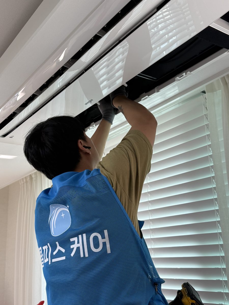 쿨피스케어 작업자가 천장형 시스템에어컨을 분해 청소하는 모습